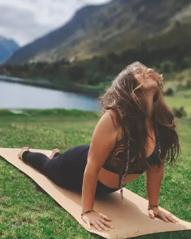 Pauline en posture du cobra sur son tapis, au bord d’un lac de montagne