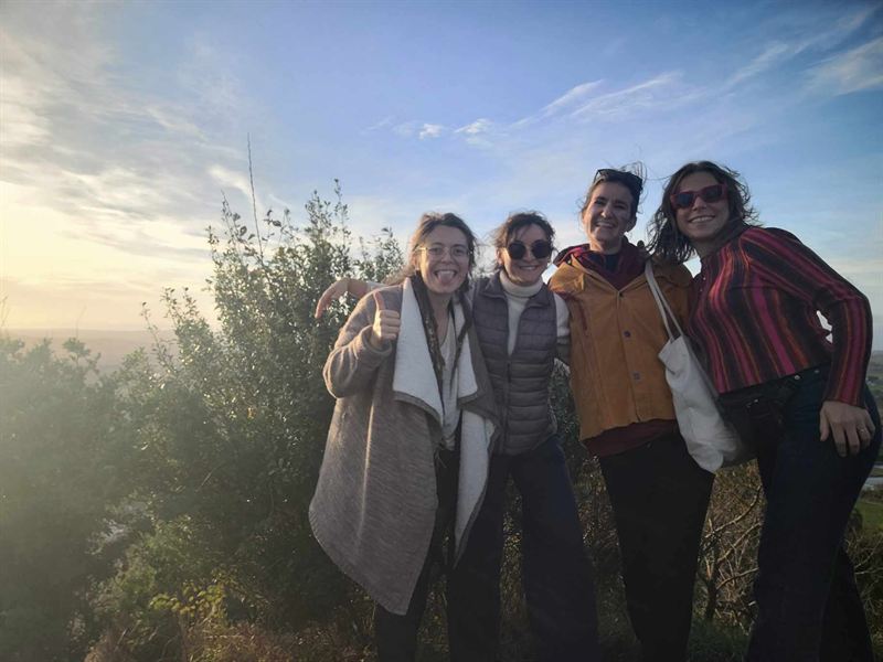 Quatre amies souriantes, réunies au lever du jour