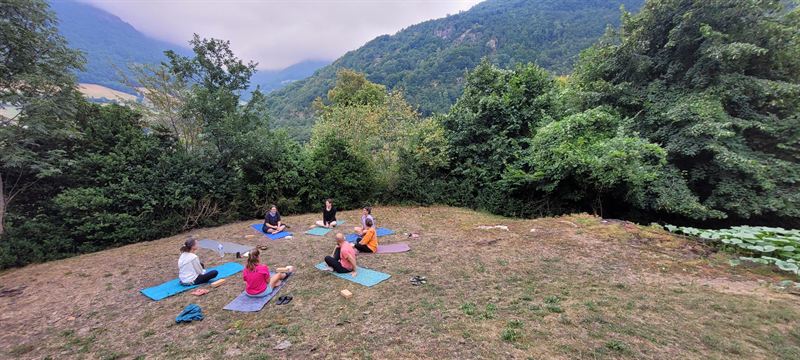 Un groupe en cercle sur ses tapis, sur une colline face aux montagnes
