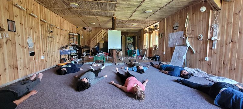 Un groupe allongé sur ses tapis dans une grande salle en bois