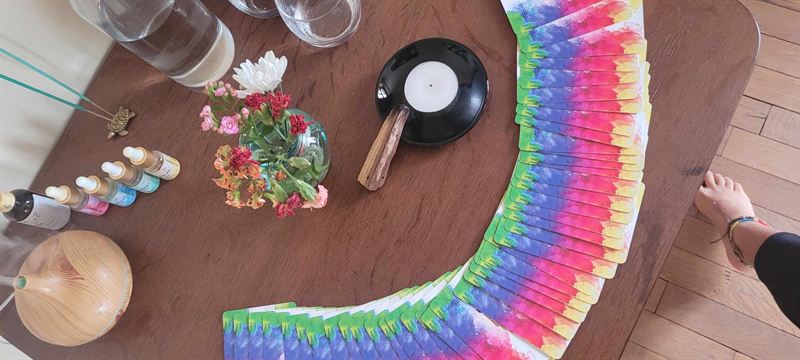 Des cartes aux couleurs des chakras disposées autour d’une bougie