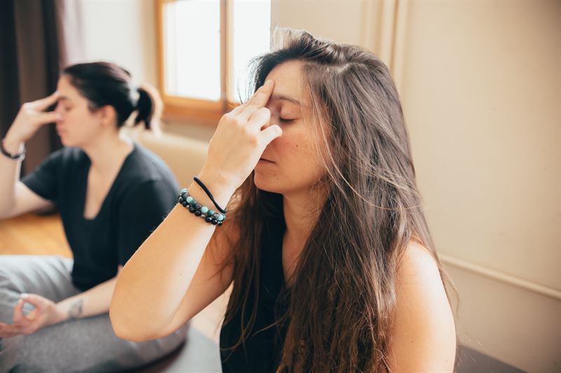 Une participante en méditation, les yeux fermés