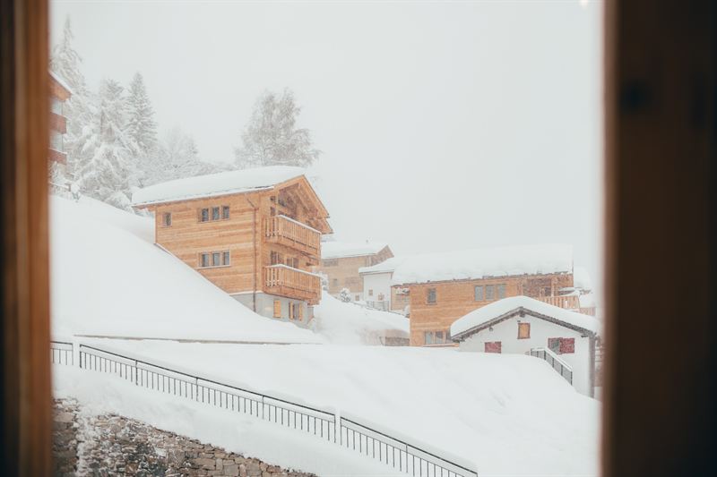 La vue depuis la salle : des chalets sous la neige