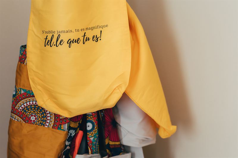 Un sac jaune et un sac en wax coloré, côte à côte