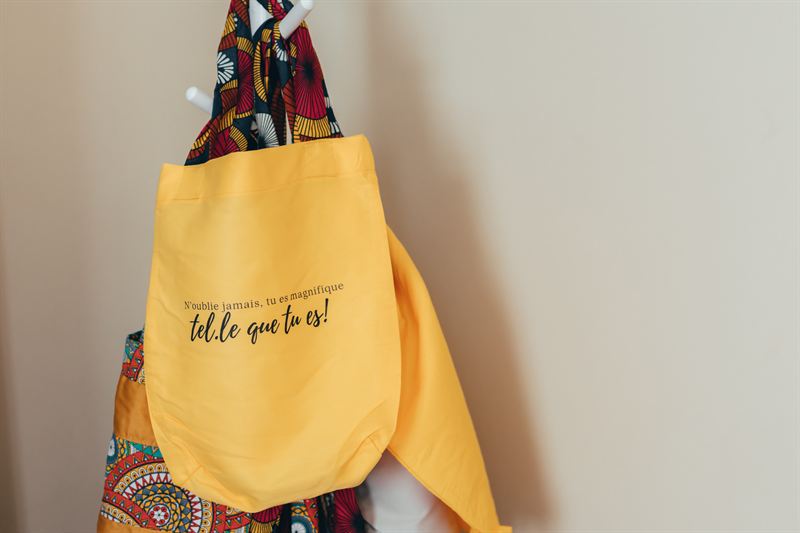 Un sac jaune Yoga Liberté suspendu, avec son message brodé