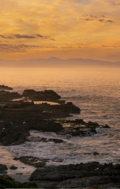 Coucher de soleil orangé sur les rochers de la côte de Gansbaai